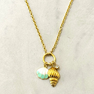 Gold necklace with gold & enamel shell charms on a light gray background